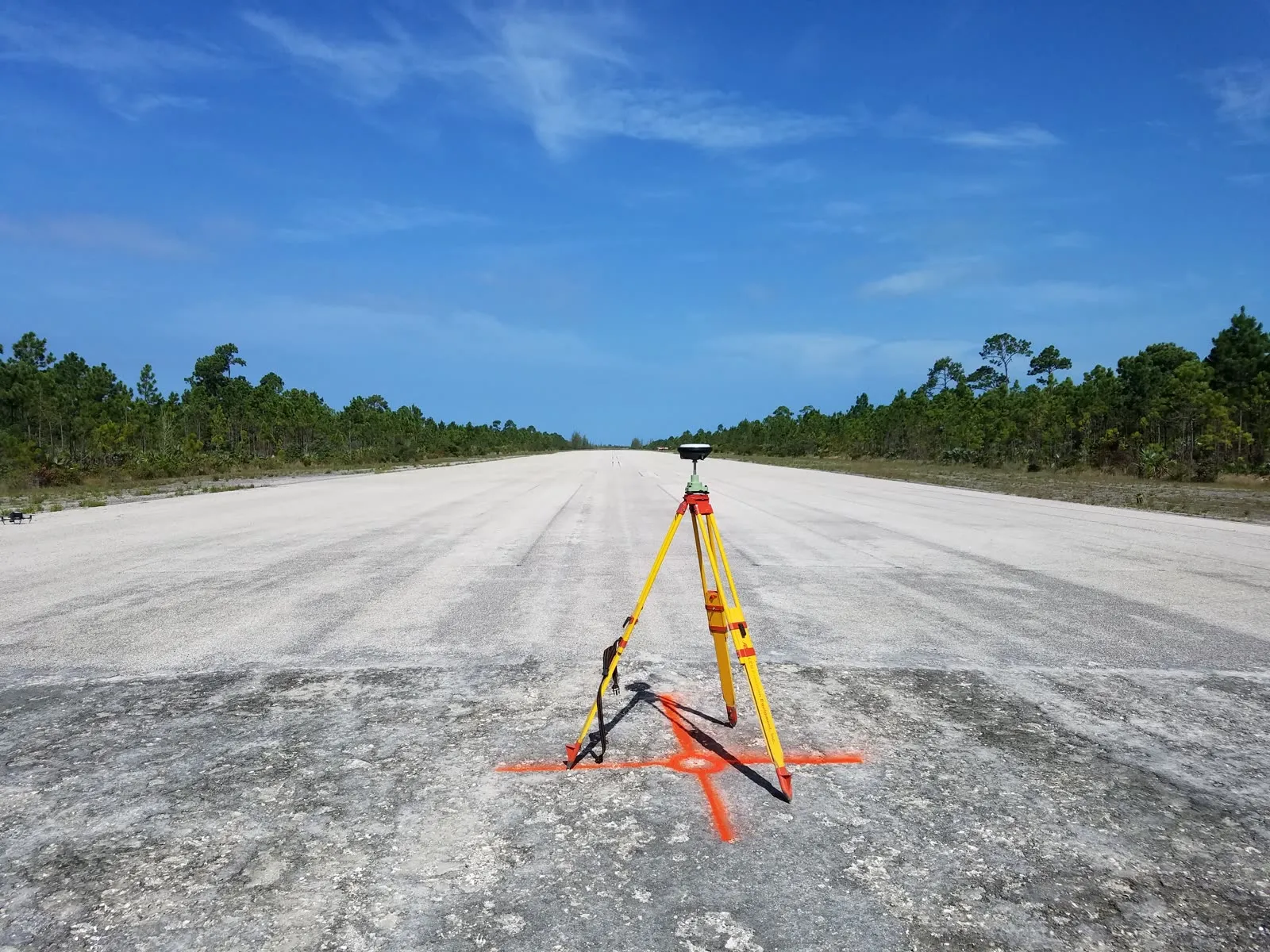 Survey instrument on a runway centerline providing ground control for aerial mapping